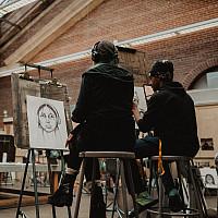 在赖特博物馆的艺术工作室里，两名学生坐在一起拍摄自画像.